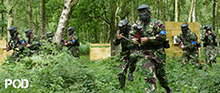 <Small image of Pod paintball player shooting >